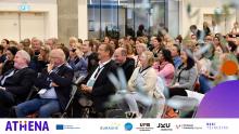 Participants at the ECER2024 Conference. The image shows a group of people sitting on chairs and looking at a speaker off-camera.